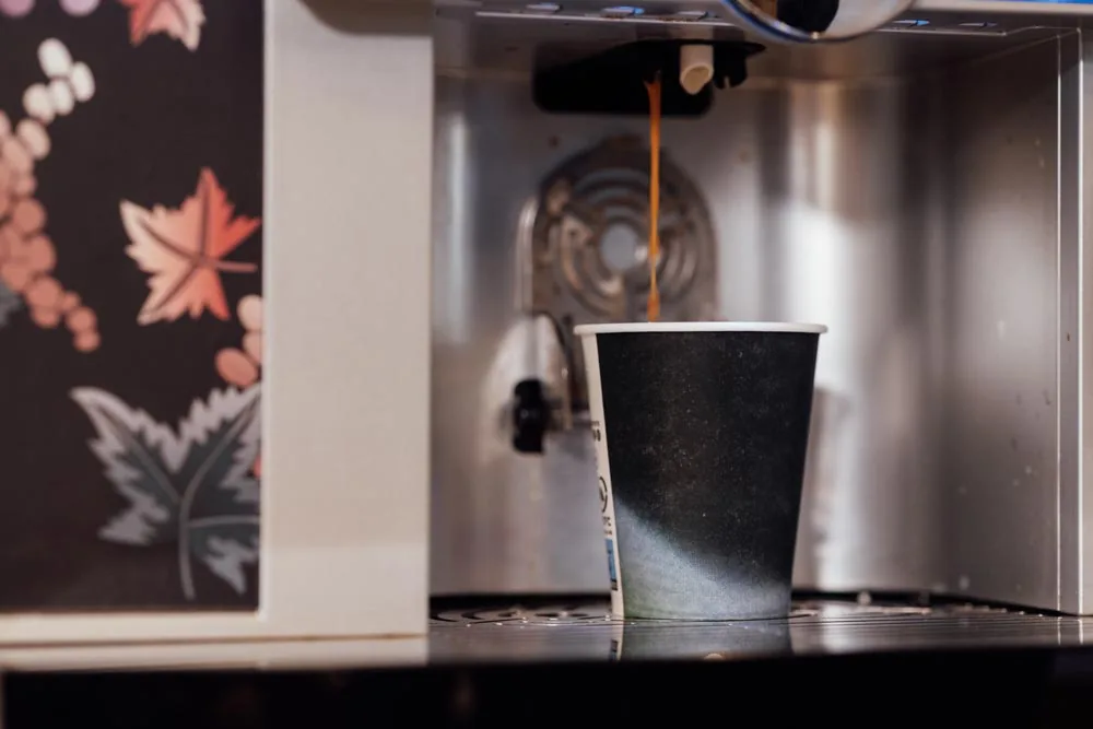 Café recién servido en la máquina de una empresa